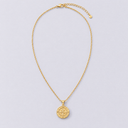 Gold compass necklace full length flat lay